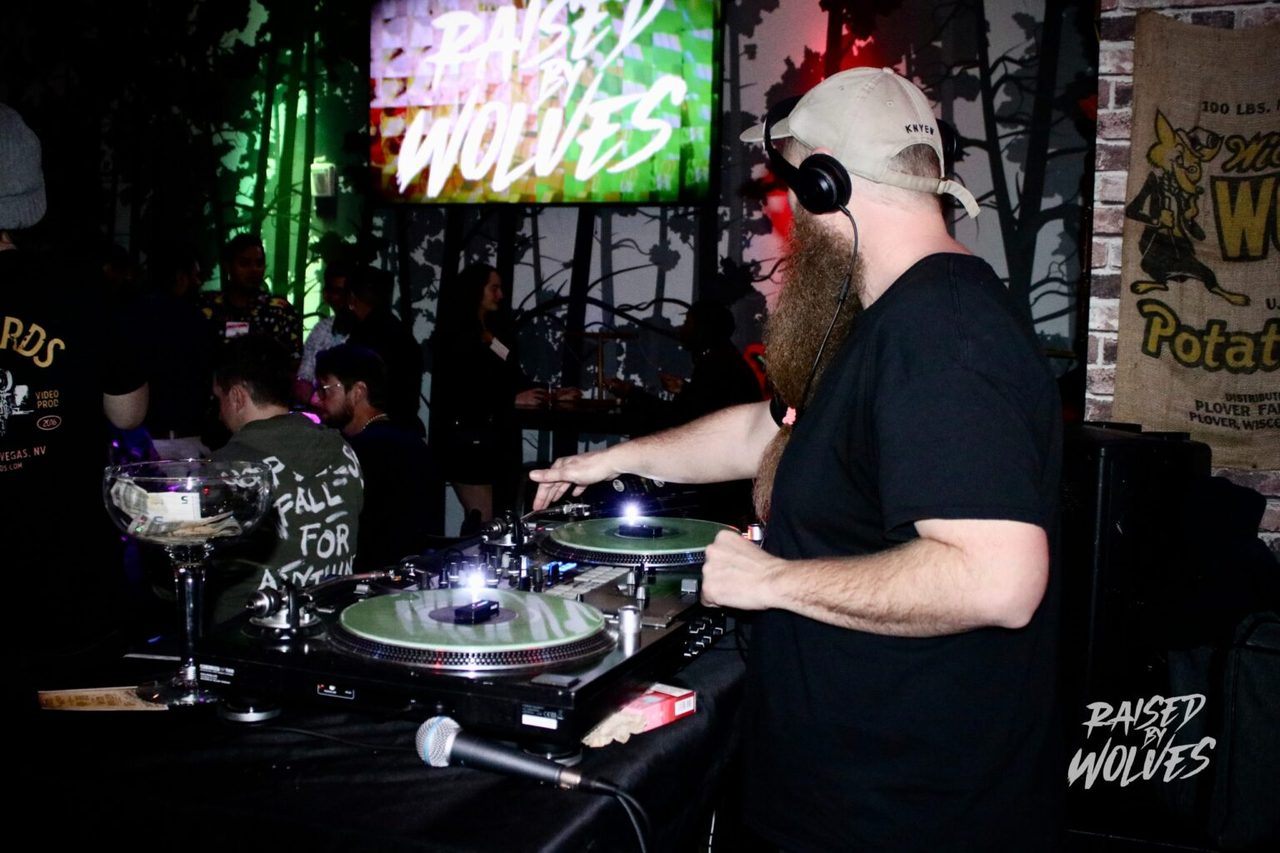 DJ spinning at Raised By Wolves under the forest mural in Downtown Las Vegas